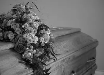 Coffin dressed with a spray of white roses, R.C. Smallbone Funeral Directors Newbury
