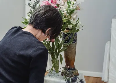 Florist arranging white flowers for a funeral tribute, R.C. Smallbone Funeral Directors Newbury