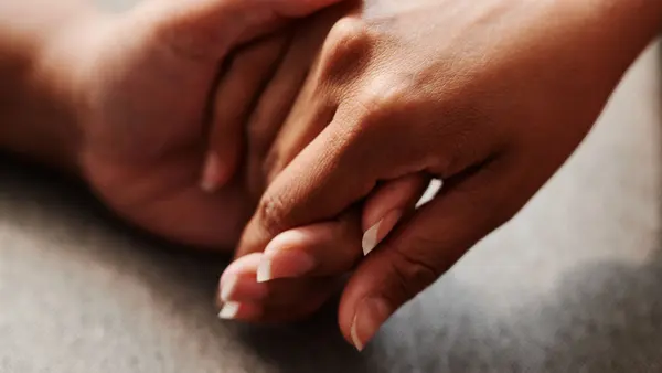 Two people holding hands in comfort, bereavement care from R.C. Smallbone Funeral Directors Newbury
